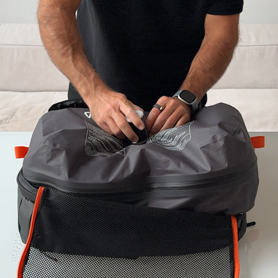 man compresses the new vacuum bag 2.0 from Jaimie Jacobs with a small compression pump.
